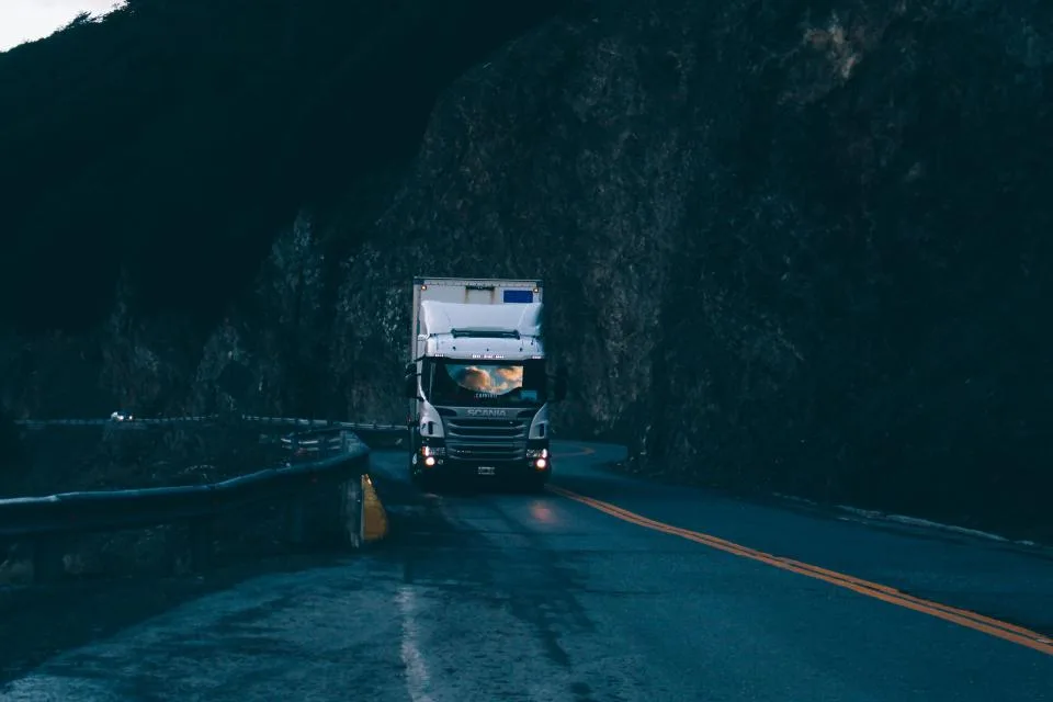 Camión de carga en carretera de montaña al atardecer