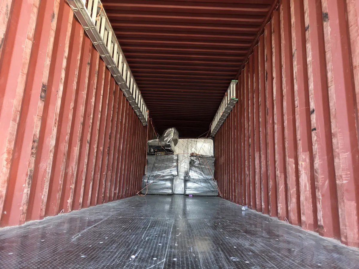 Interior de contenedor con muebles embalados y asegurados con red